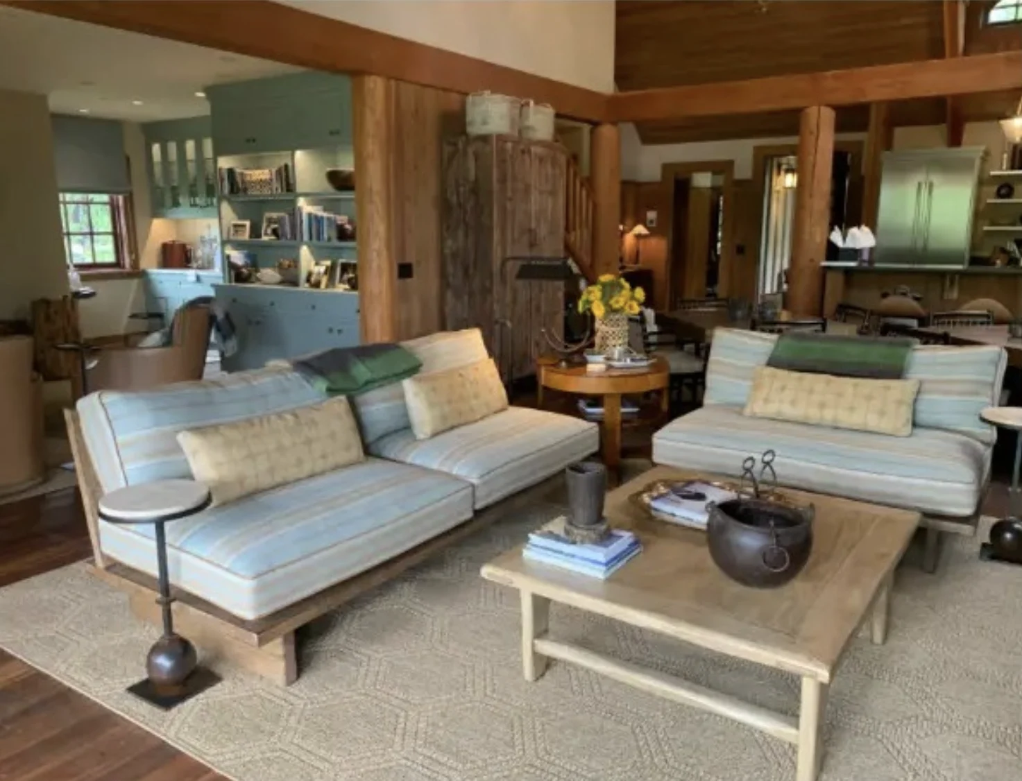 Family room with striped low sofas, an oak coffee table, and timber beams